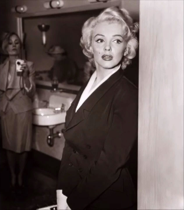 Người phụ nữ phía sau Marilyn Monroe cầm đồ vật giống máy ảnh hiện đại.